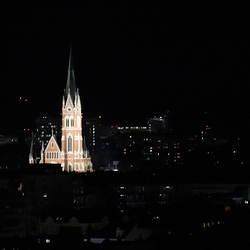 Grazer Herz-Jesu-Kirche vom Dach des Styria Media Centers bei Nacht.