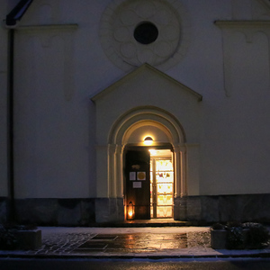 Beleuchteter Eingang der Pfarrkirche Dobl am Abend
